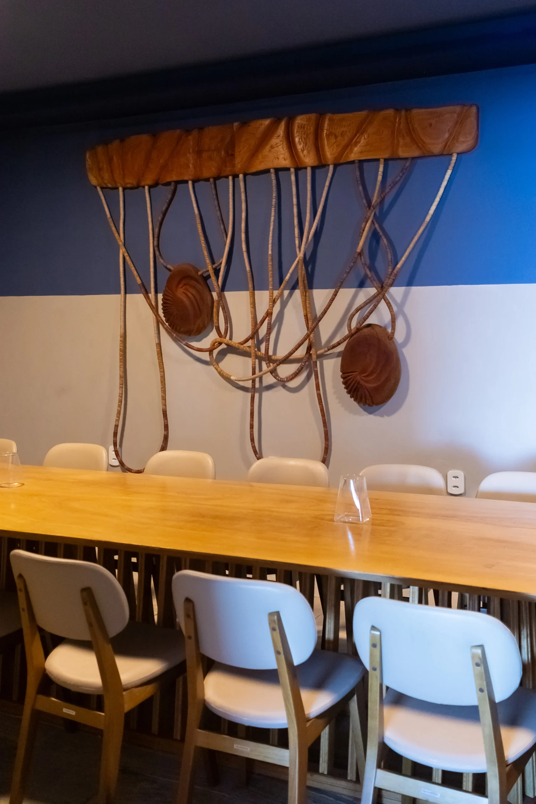 Sala privativa com mesa longa e arte na parede